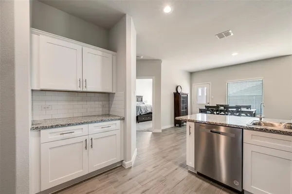 a kitchen with white cabinets and stainless steel appliances