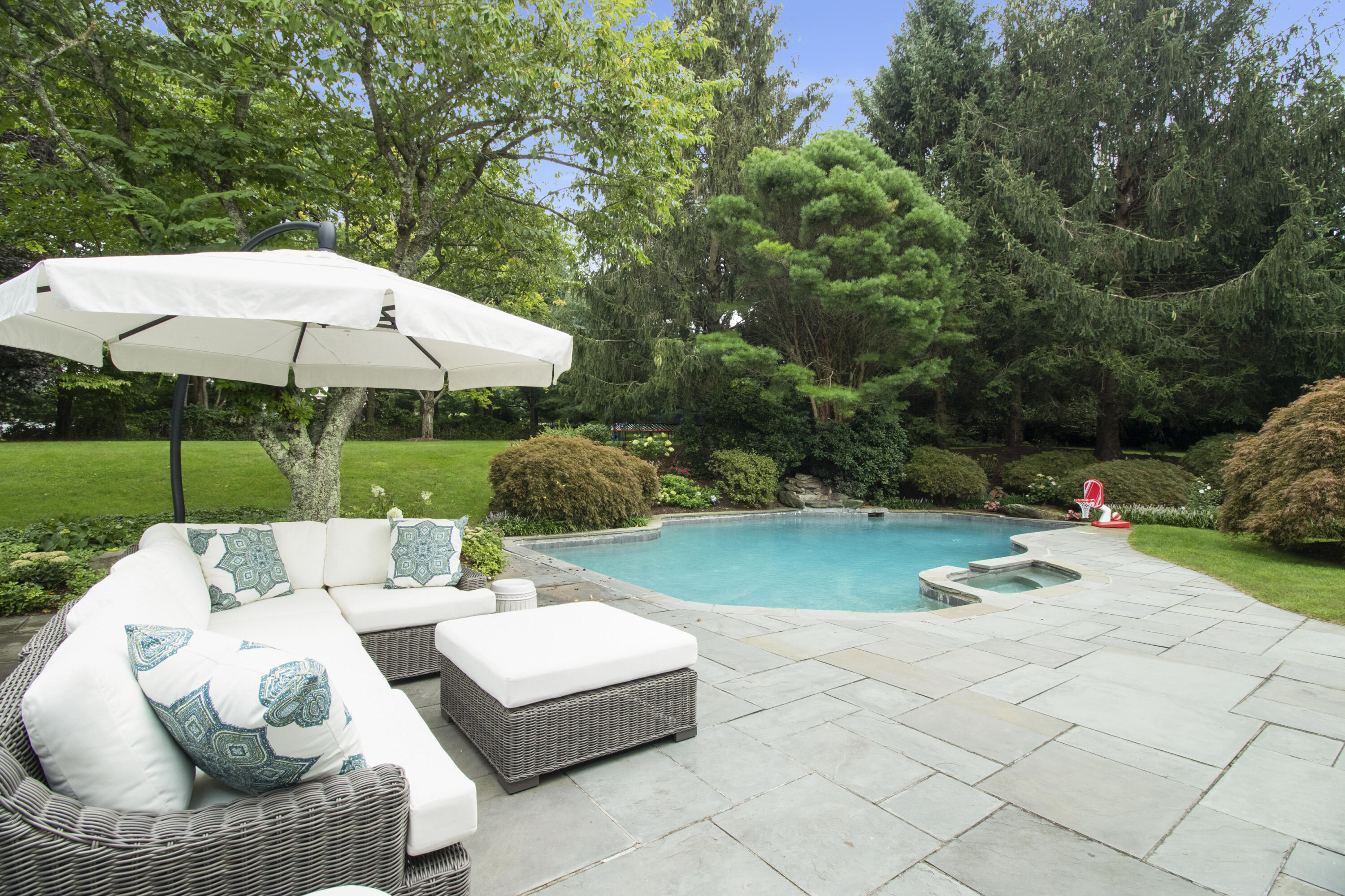 40 Pear Tree Point Road Darien, CT 06820 - Photo 4 of 50 a patio with a table and chairs under an umbrella