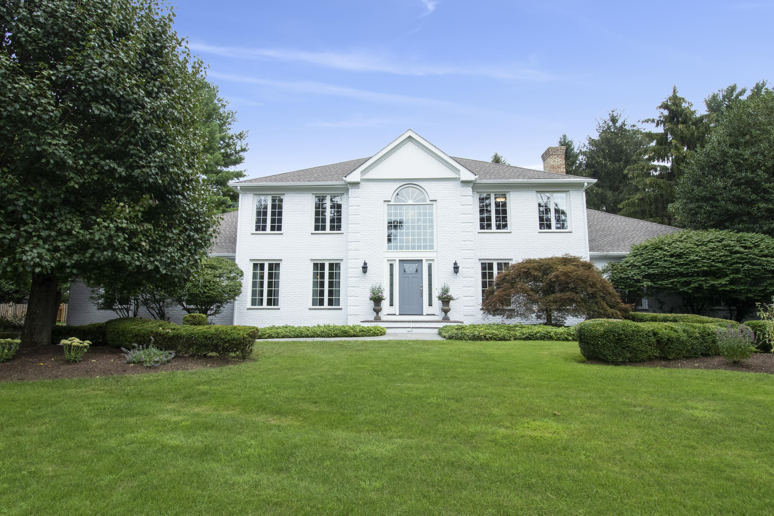 40 Pear Tree Point Road Darien, CT 06820 - Photo 5 of 50 a front view of a house with a garden and trees