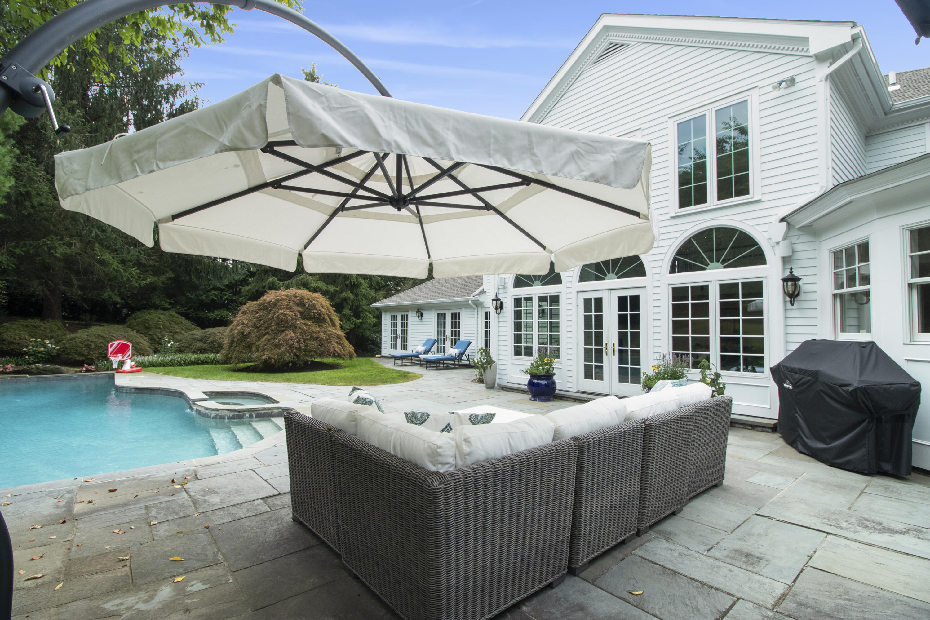 40 Pear Tree Point Road Darien, CT 06820 - Photo 46 of 50 a patio table and chairs under an umbrella