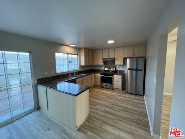 a kitchen with granite countertop stainless steel appliances and wooden cabinets