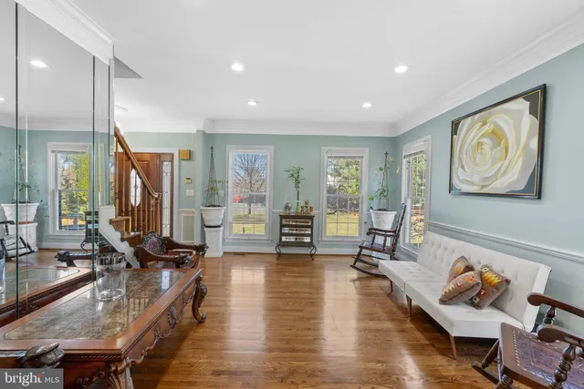 a kitchen with stainless steel appliances granite countertop a refrigerator a stove top oven a sink dishwasher a dining table and chairs with wooden floor