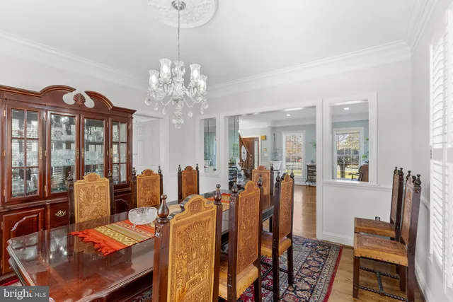 a kitchen with stainless steel appliances a dining table chairs stove and white cabinets