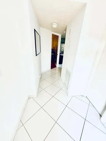 a living room with furniture a flat screen tv and floor to ceiling window