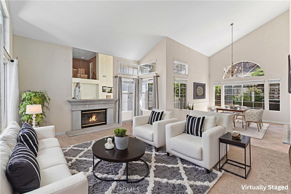 a living room with furniture a fireplace and a chandelier