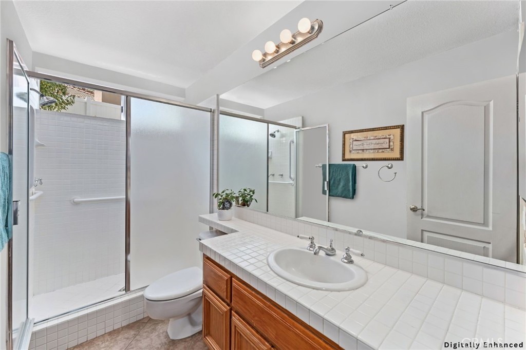 4150 San Ramon Drive Corona, CA 92882 - Photo 21 of 30 a bathroom with a granite countertop sink a toilet a mirror and shower