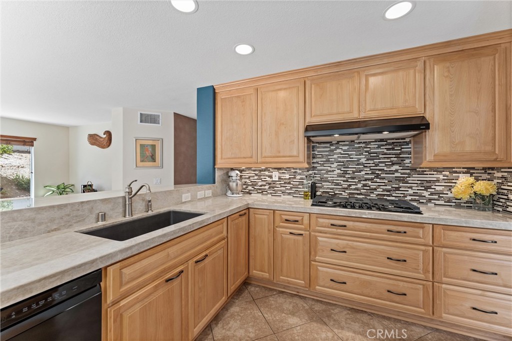 4150 San Ramon Drive Corona, CA 92882 - Photo 9 of 30 a kitchen with granite countertop a sink dishwasher stove and cabinets