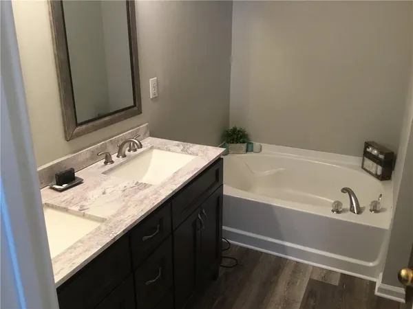 a bathroom with a granite countertop sink and a bathtub