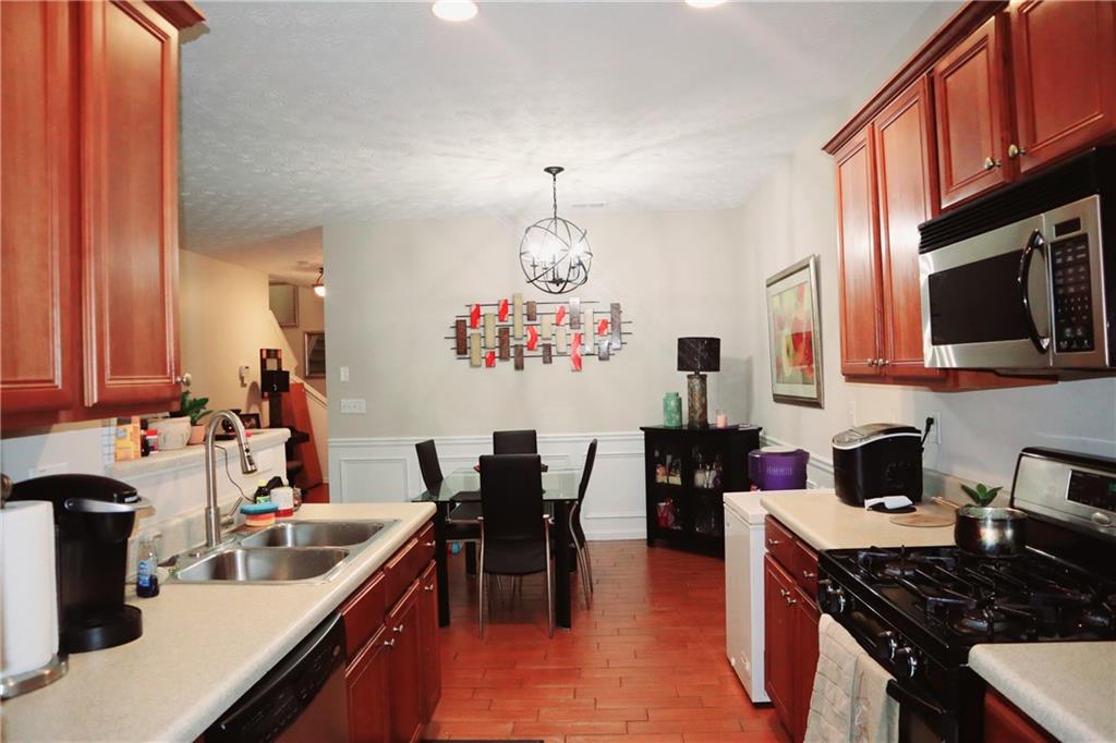 789 Celeste Lane Atlanta, GA 30331 - Photo 5 of 18 a kitchen with stainless steel appliances granite countertop a stove top oven a sink dishwasher and cabinets with wooden floor