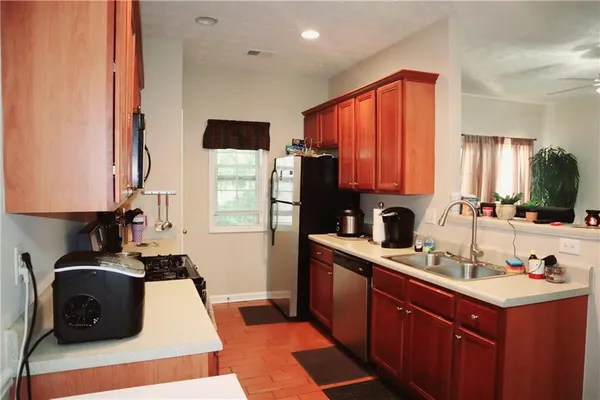 a kitchen with stainless steel appliances a sink stove and refrigerator
