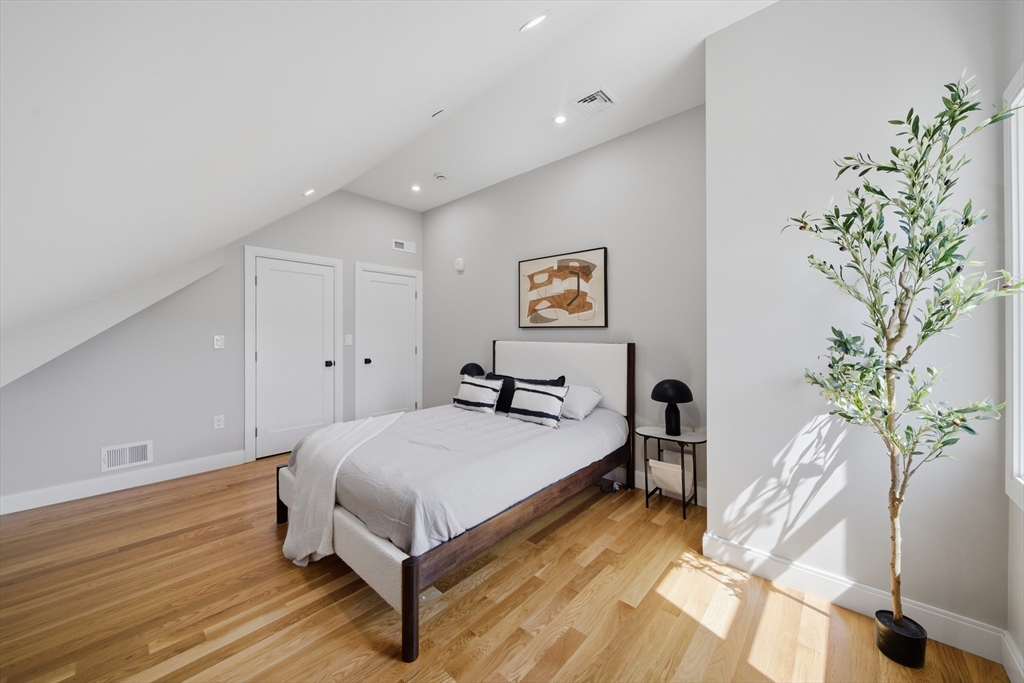 174 Walnut Street, Unit 3 Somerville, MA 02145 - Photo 19 of 38 a spacious bedroom with a bed and a plant