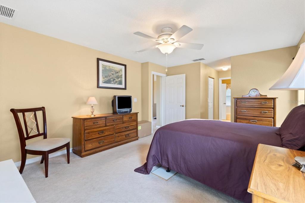 17083 Southeast 115th Terrace Road Summerfield, FL 34491 - Photo 20 of 43 a bedroom with a bed and a chandelier