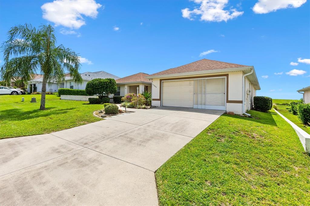 17083 Southeast 115th Terrace Road Summerfield, FL 34491 - Photo 4 of 43 a front view of a house with a yard and potted plants