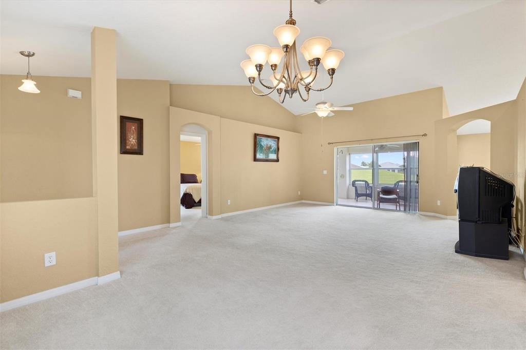 17083 Southeast 115th Terrace Road Summerfield, FL 34491 - Photo 9 of 43 a view of a livingroom with furniture a chandelier and wooden floor