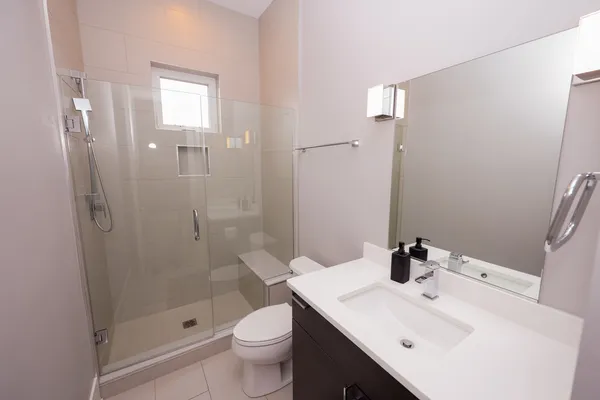 a spacious bathroom with a tub shower and mirror
