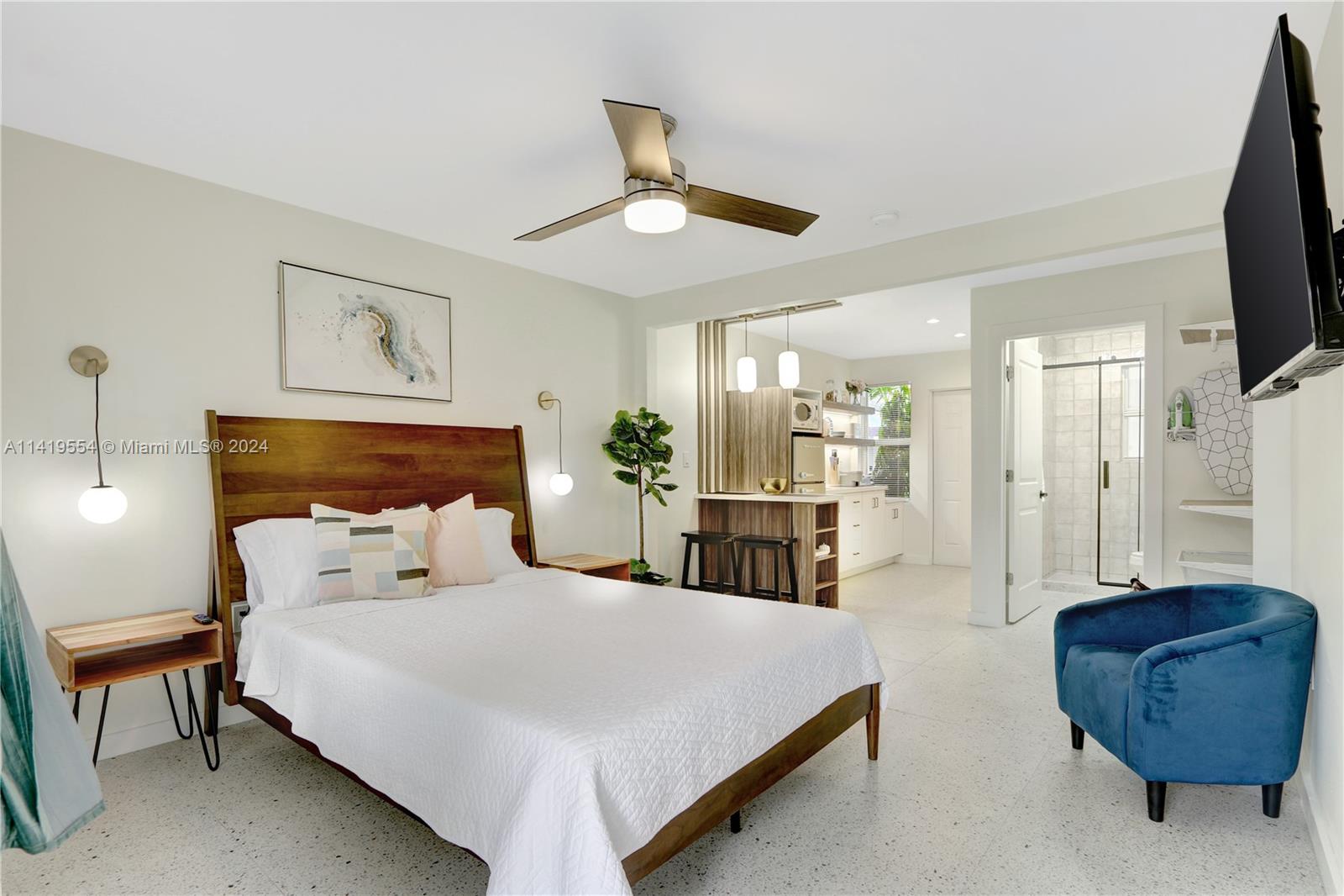 Palm Trail Delray Beach, FL 33483 - Photo 19 of 55 a bedroom with a bed a couch and a flat screen tv