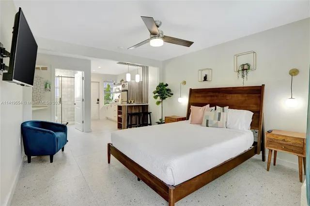 a bedroom with a bed a couch and a flat screen tv