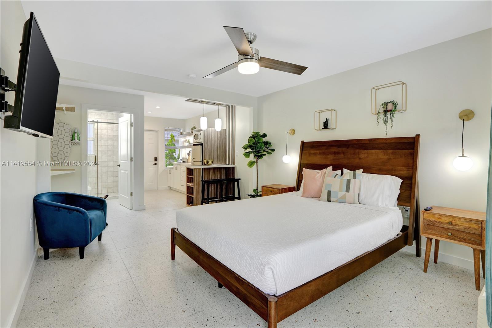 Palm Trail Delray Beach, FL 33483 - Photo 23 of 55 a bedroom with a bed a couch and a chandelier