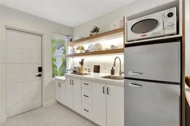 a kitchen with white cabinets and white refrigerator