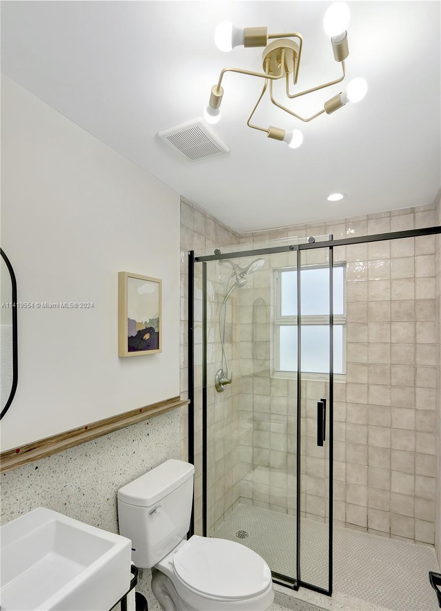 Palm Trail Delray Beach, FL 33483 - Photo 26 of 55 a bathroom with a toilet sink and shower