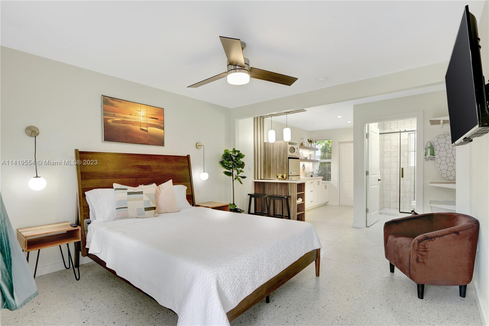 Palm Trail Delray Beach, FL 33483 - Photo 27 of 55 a bedroom with a bed a couch and a flat screen tv