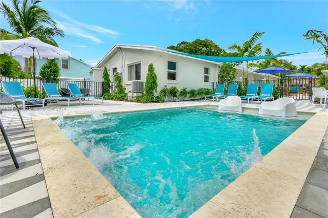 a view of a patio with table and chairs under an umbrella