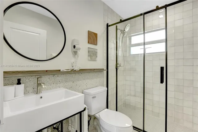 a bathroom with a toilet a sink and a mirror