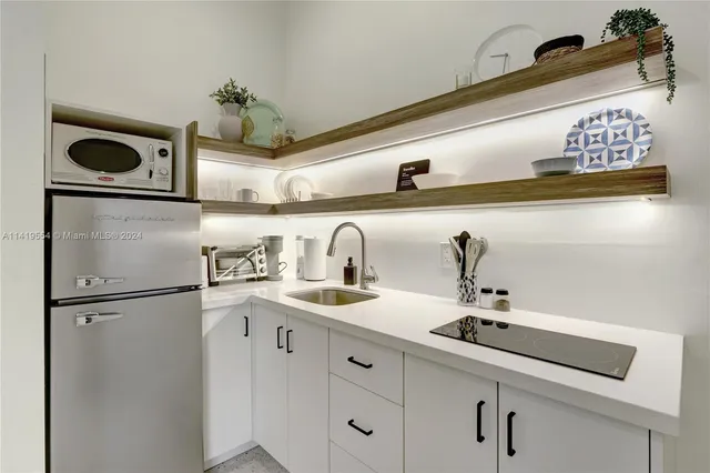 a kitchen with stainless steel appliances a sink and a refrigerator