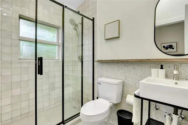 a bathroom with a toilet a sink and shower