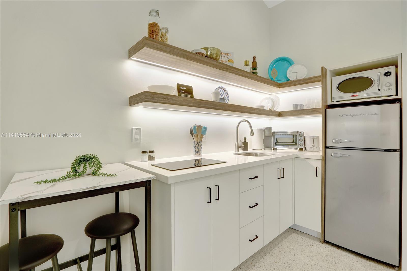 Palm Trail Delray Beach, FL 33483 - Photo 47 of 55 a kitchen with stainless steel appliances a sink and a refrigerator