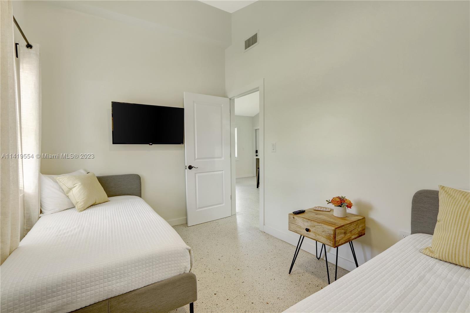 Palm Trail Delray Beach, FL 33483 - Photo 54 of 55 a hotel room with a bed and a flat screen tv