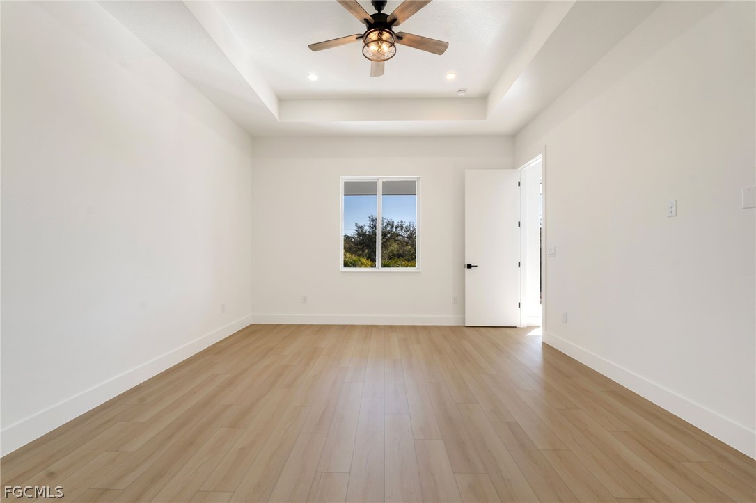 95 Brig Circle East Placida, FL 33946 - Photo 15 of 25 an empty room with wooden floor chandelier fan and windows
