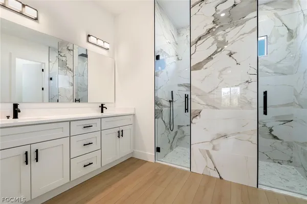 a bathroom with a double vanity sink toilet and shower