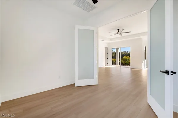 a view of a hallway with wooden floor and closet