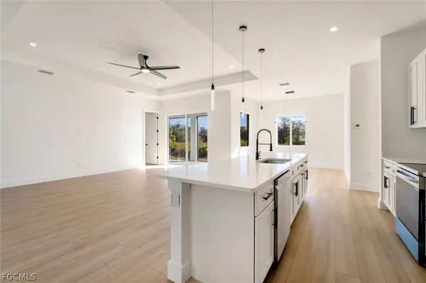 a kitchen with granite countertop a sink appliances counter top space and cabinets