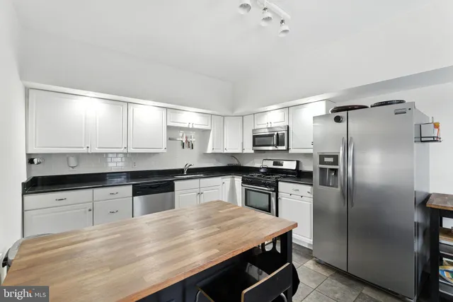 a kitchen with stainless steel appliances granite countertop a sink refrigerator and microwave