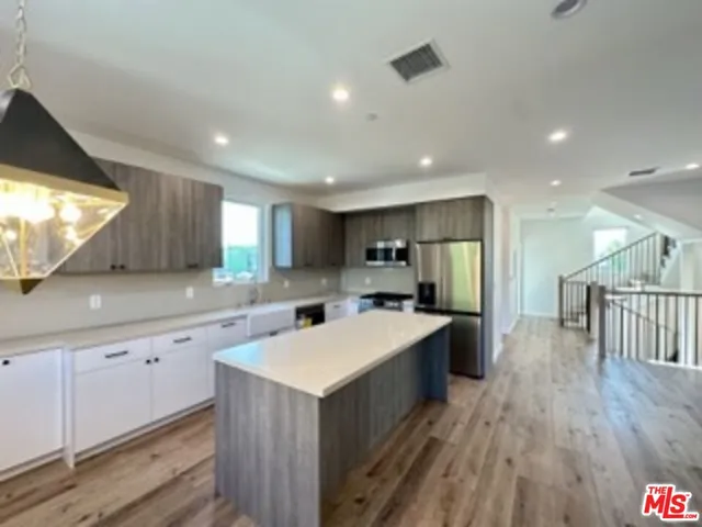 a kitchen with a sink a counter top space stainless steel appliances and a window