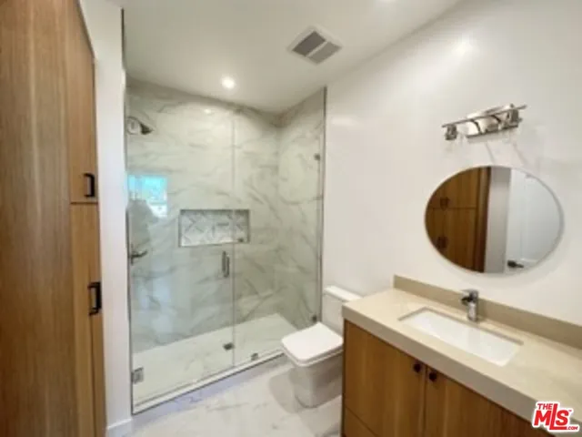 a bathroom with a granite countertop sink a toilet and a mirror