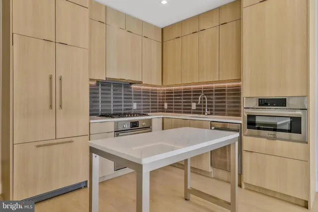 a kitchen with stainless steel appliances a stove a sink and a refrigerator