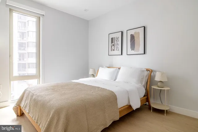 a large bed sitting in a bedroom next to a window