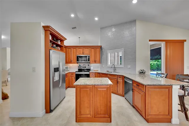 a kitchen with stainless steel appliances granite countertop a sink and a refrigerator