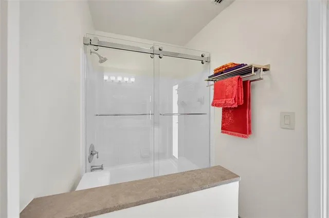 a bathroom with a granite countertop shower sink and vanity