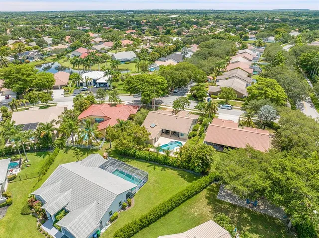 an aerial view of residential houses with outdoor space and trees