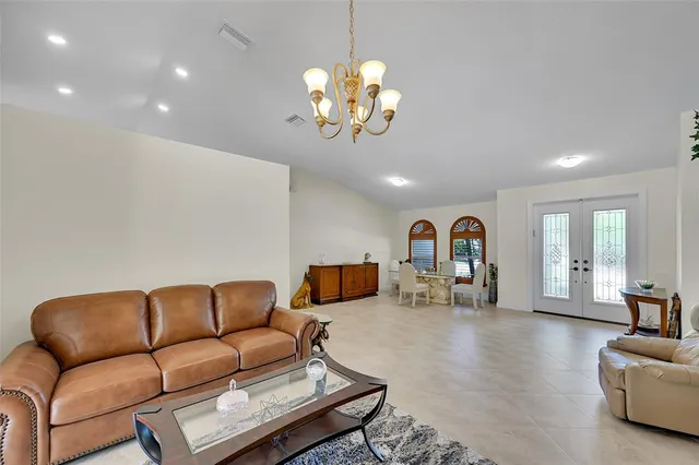 a living room with furniture a chandelier and a flat screen tv