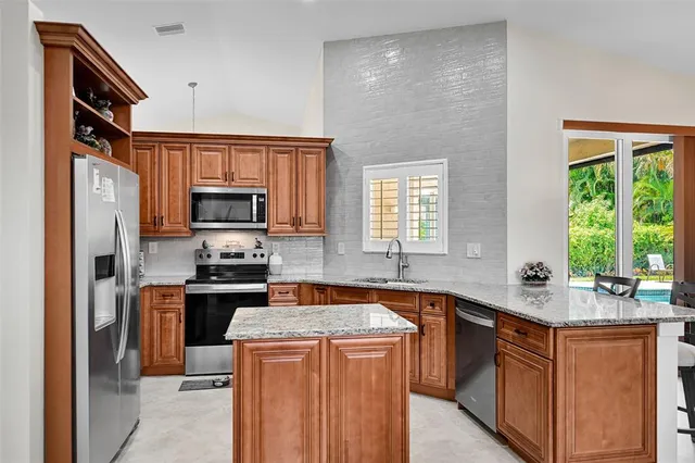 a kitchen with stainless steel appliances granite countertop a sink stove and refrigerator