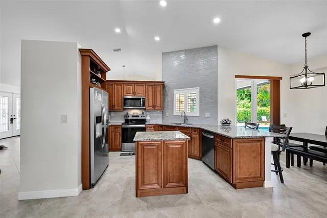 a kitchen with kitchen island a counter top space appliances and a window