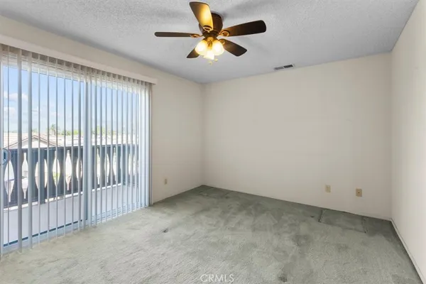 an empty room with a window and a ceiling fan