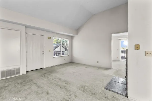 an empty room with fireplace and windows