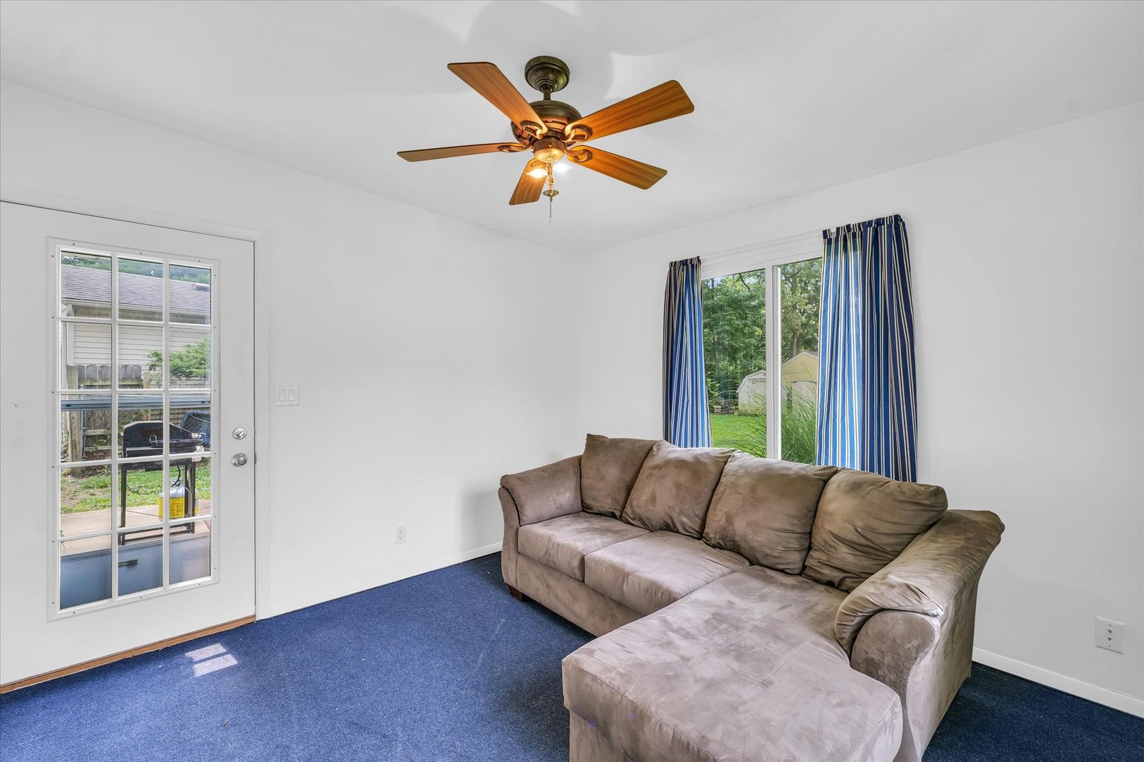 1617 Cornell Drive Champaign, IL 61821 - Photo 13 of 31 a blue couch sitting in a living room next to a window