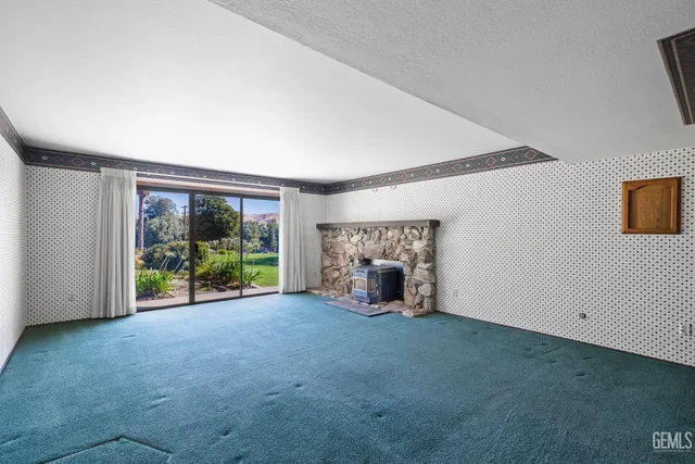 an empty room with wooden floor and a fireplace